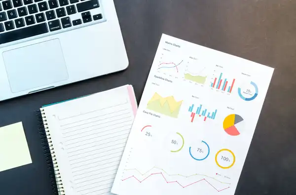 Notebooks and a sheet with graphs lying on a desk