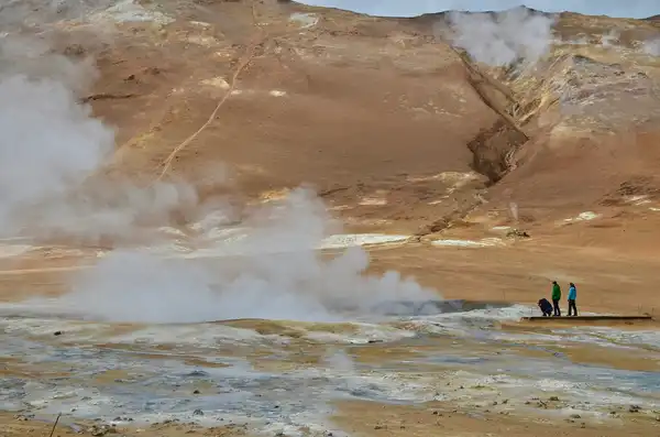 People standing next to a hot spring